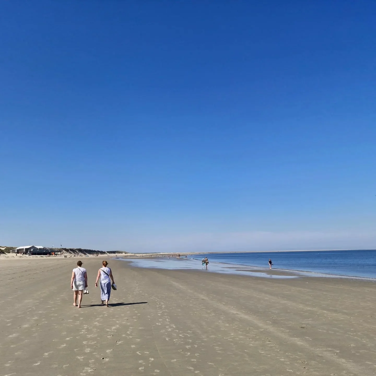Two people walking on a beach, relaxed